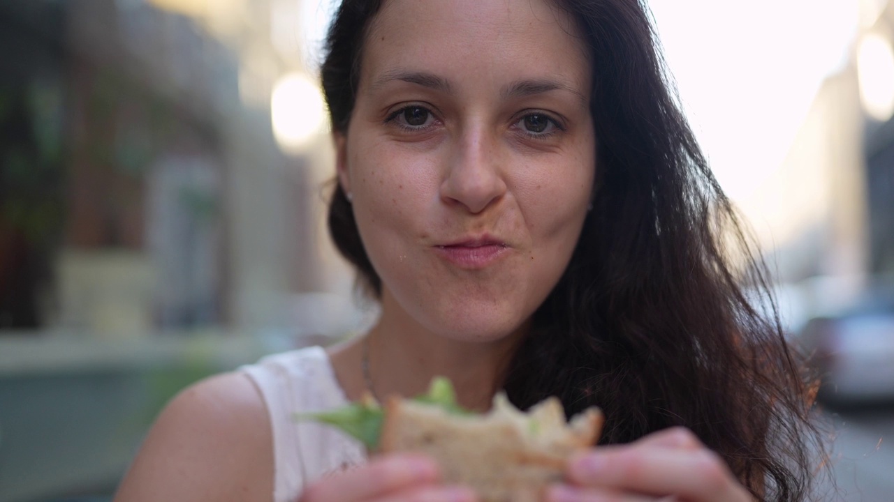 在路边咖啡馆吃素食三明治的女人视频下载