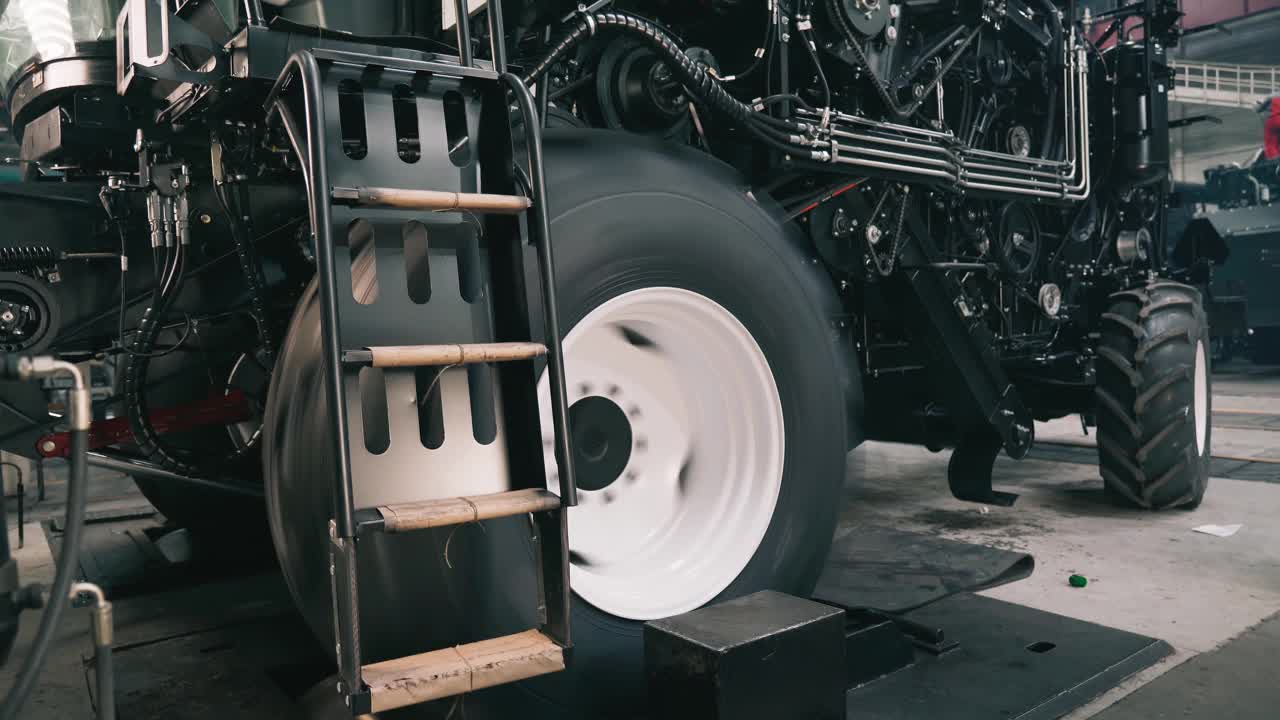工业机械厂农用拖拉机或联合收割机的初步调整。车轮在专用支架上试验和磨合视频素材