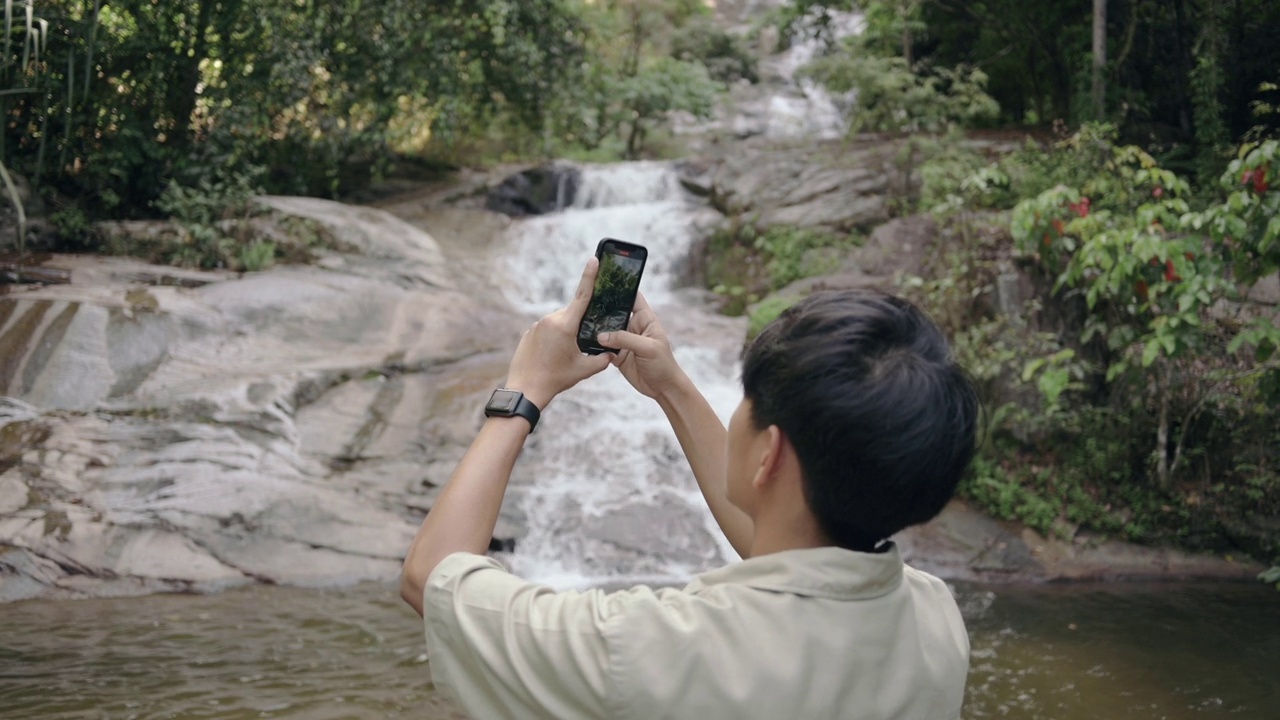 独自旅行年轻的亚洲人喜欢户外冒险，拍照，社交媒体，旅行者使用手机旅行在森林露营视频下载
