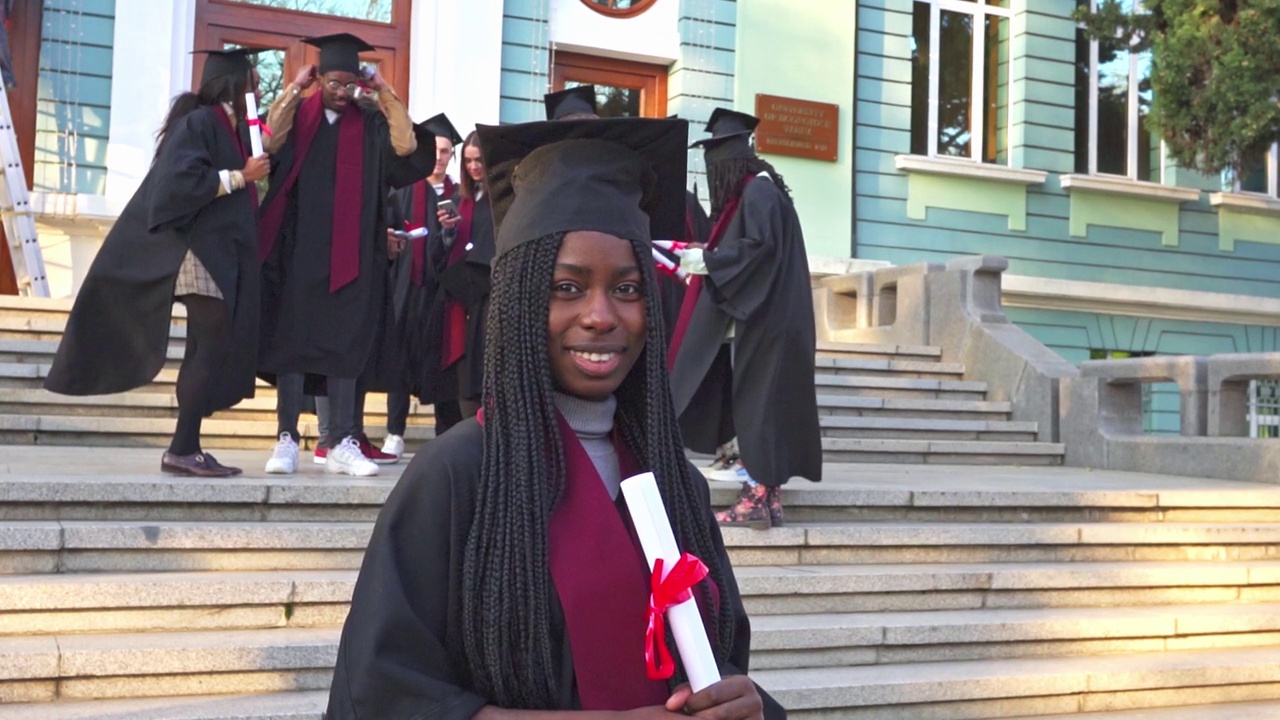 一名女毕业生在毕业典礼上穿着长袍和学位帽的肖像视频素材