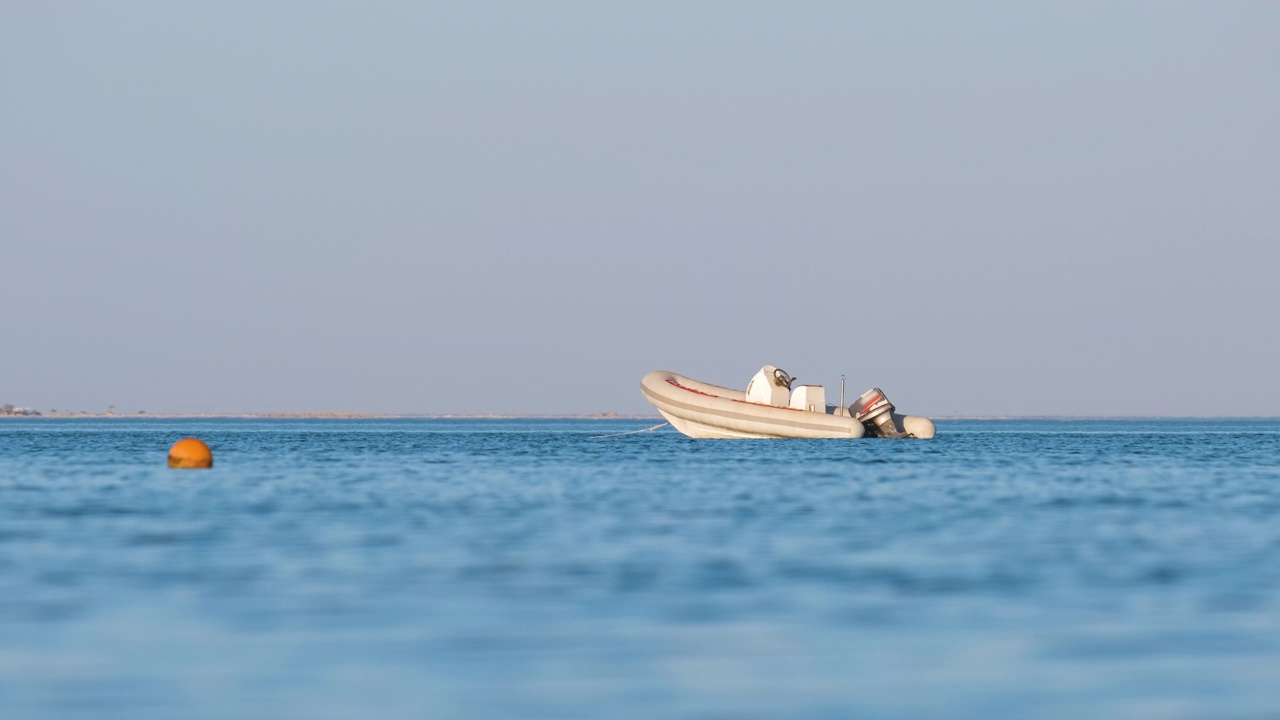 蓝色的海水泛起涟漪，白色的快艇停泊在平静的波浪上视频素材