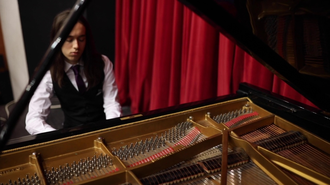痴迷于音乐的美和钢琴的声音，钢琴家弹奏着三角钢琴，享受着它视频下载