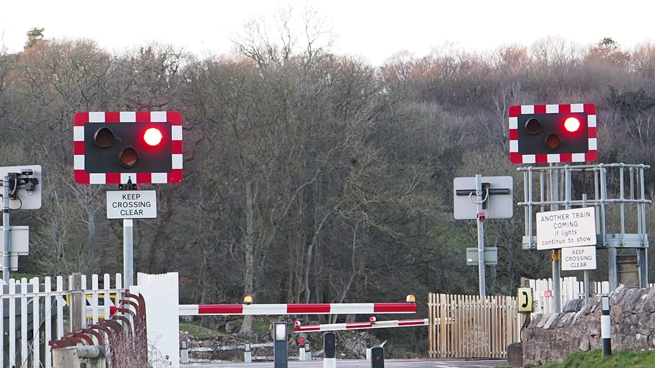 在英国兰开夏郡西尔弗代尔附近，一辆火车正驶过铁轨上的一个平交道口。视频下载