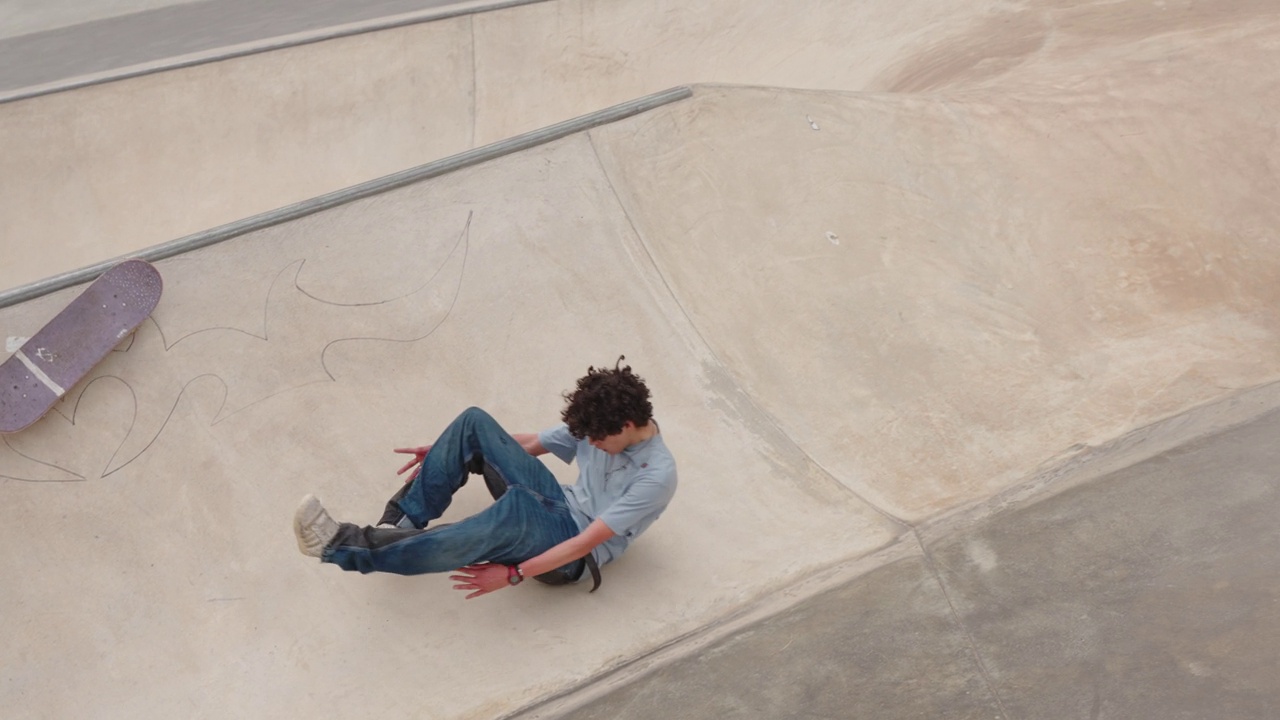 少年玩滑板时从滑板上摔下来视频下载