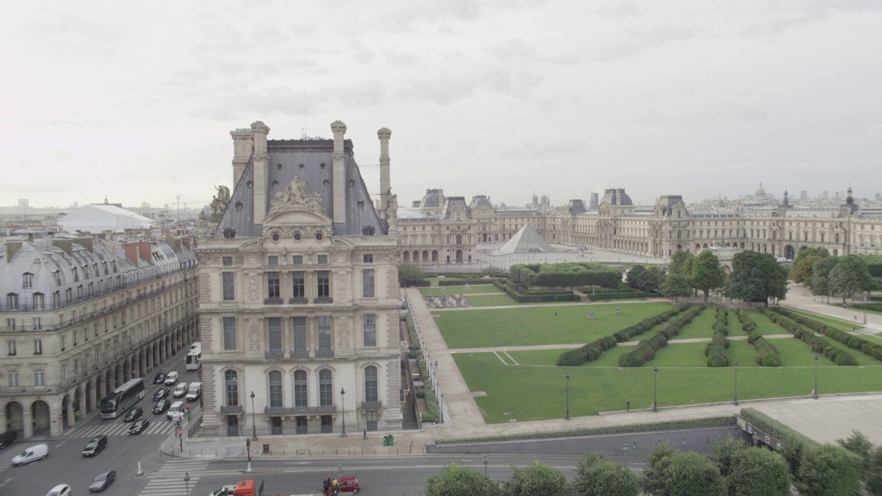 空中180度旋转，从左到右经过卢浮宫博物馆和玻璃金字塔，到达杜伊勒里花园或公园和喷泉。可见埃菲尔铁塔在bg。视频下载
