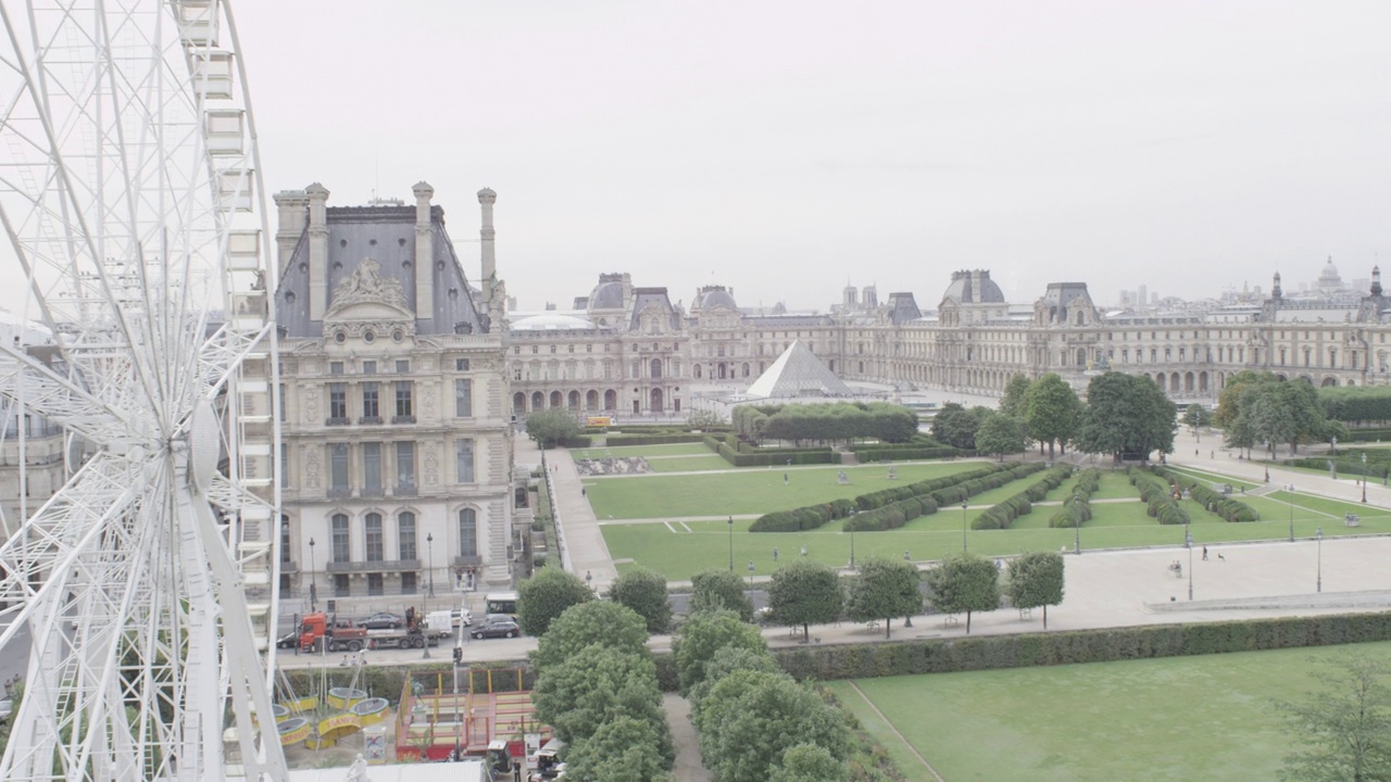 空中放大巴黎卢浮宫的玻璃金字塔。镜头聚焦过去的摩天轮。视频下载