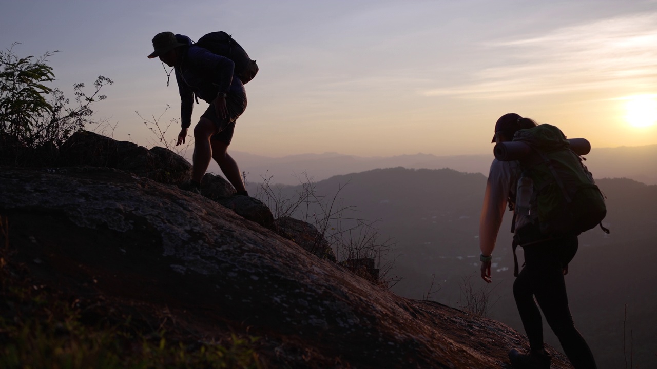 两名徒步旅行者在登山途中帮助攀上山顶视频下载