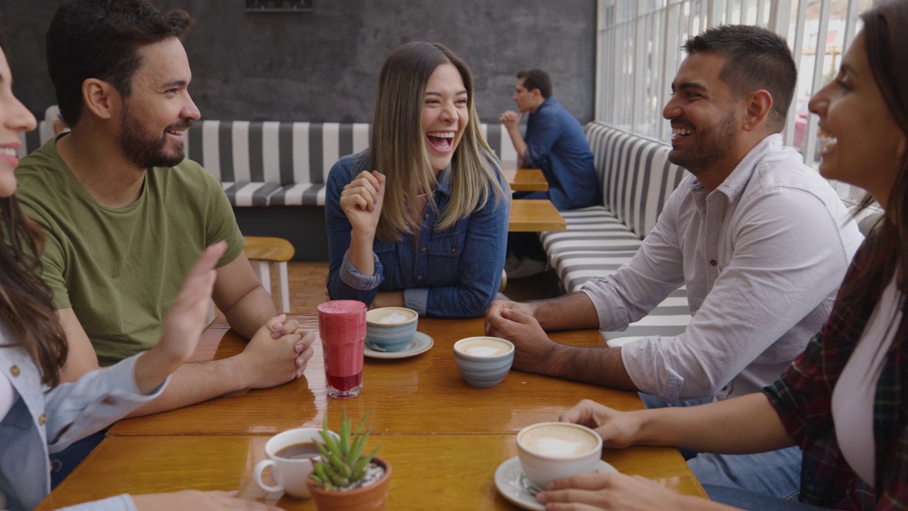 一群快乐的拉丁美洲人聚在一起喝咖啡，笑着视频素材