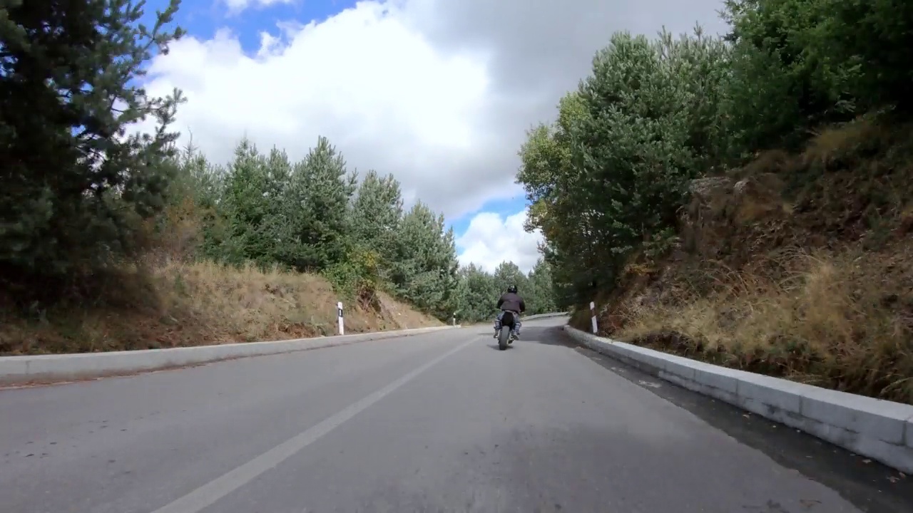 快速摩托车特技公路骑。在山区乡村公路上驾驶危险的前轮车视频素材