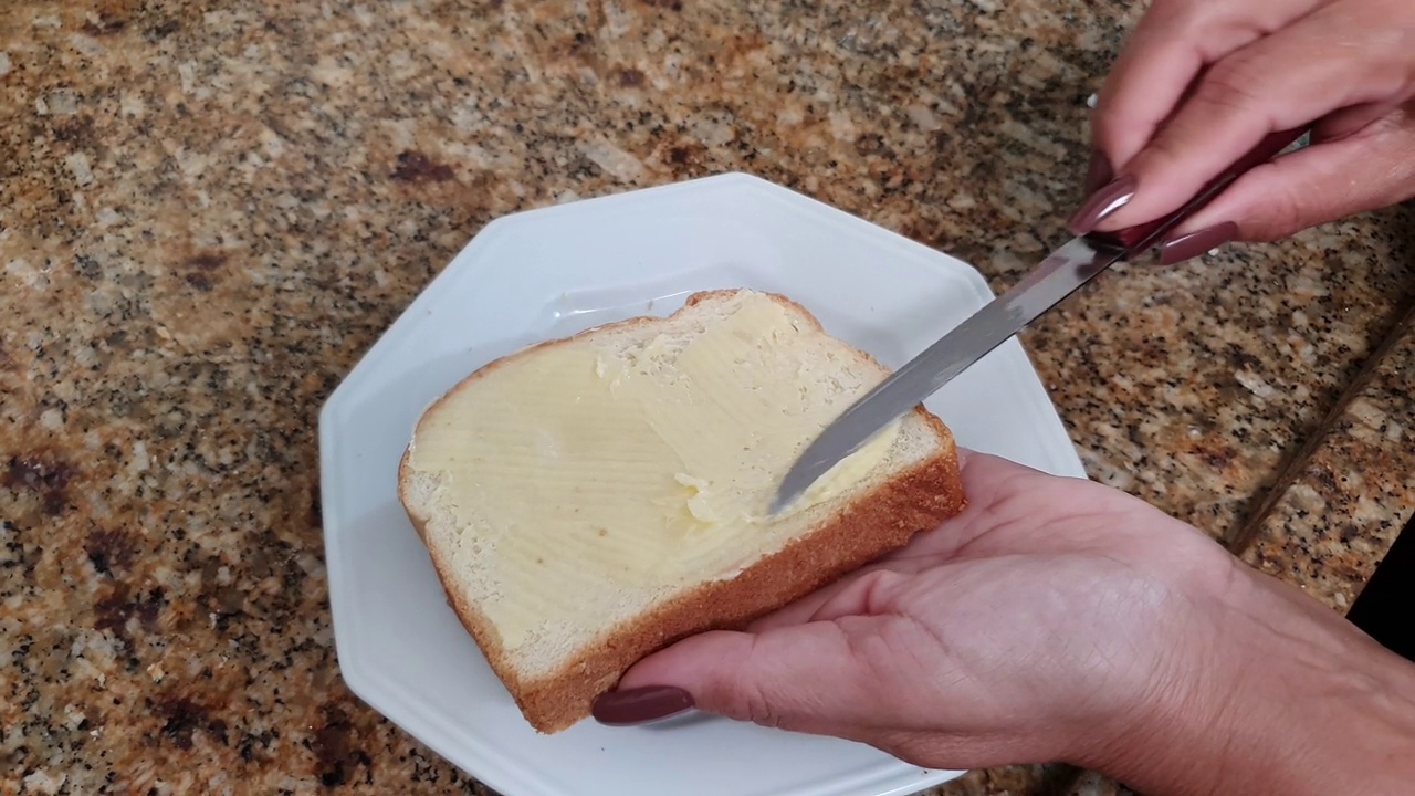 妇女在面包上涂黄油视频素材