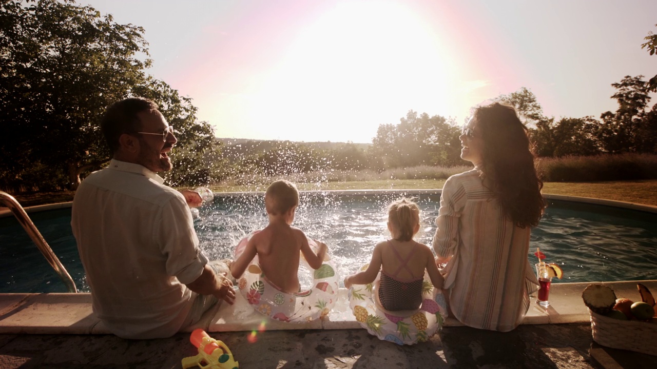 幸福的一家人在夏日的泳池边玩耍。视频素材