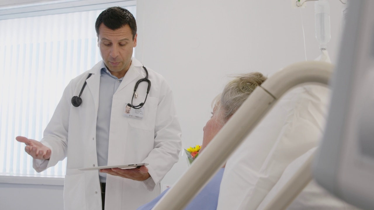 医生用数码平板电脑与病床上的病人交谈视频素材