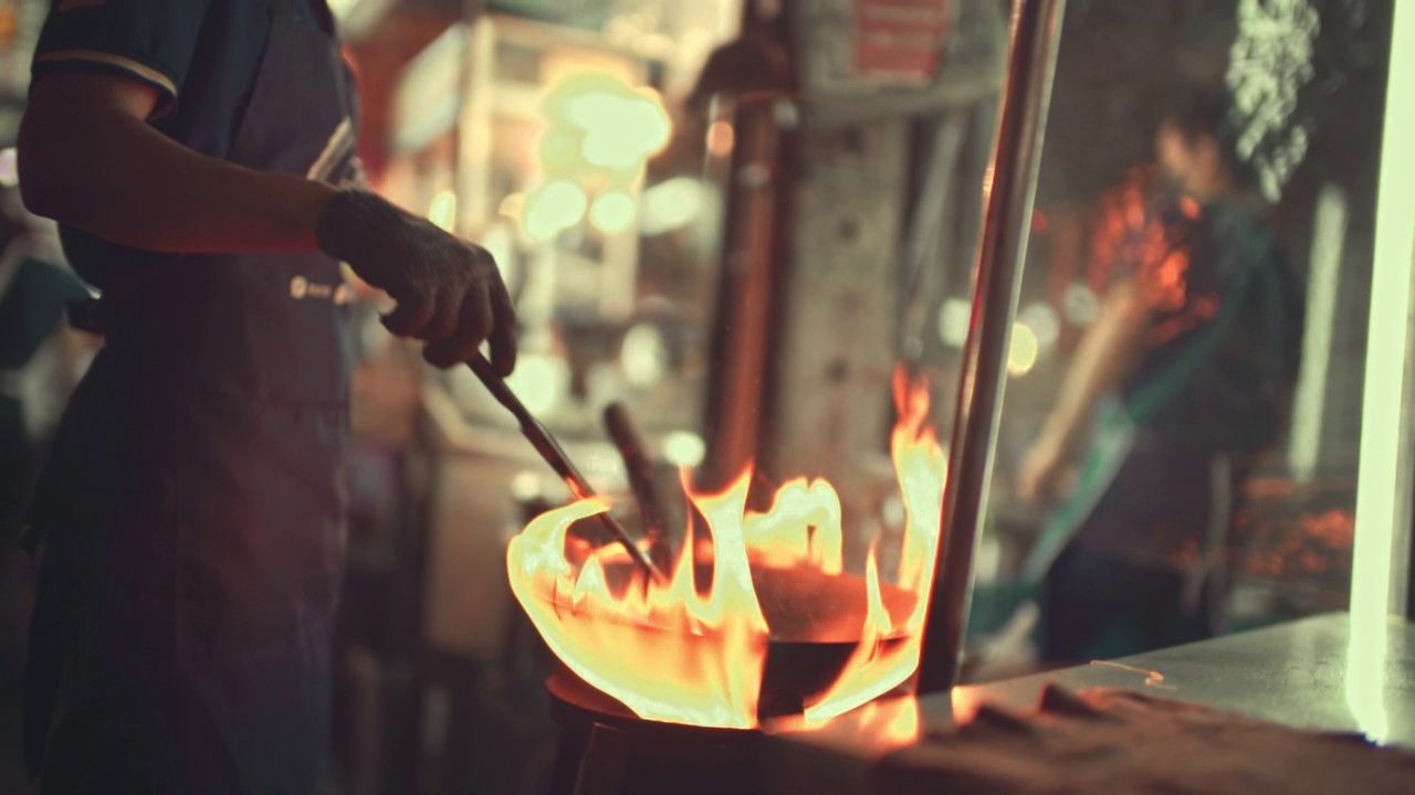 厨师在厨房炉子上用煎锅里的火焰烹饪视频下载