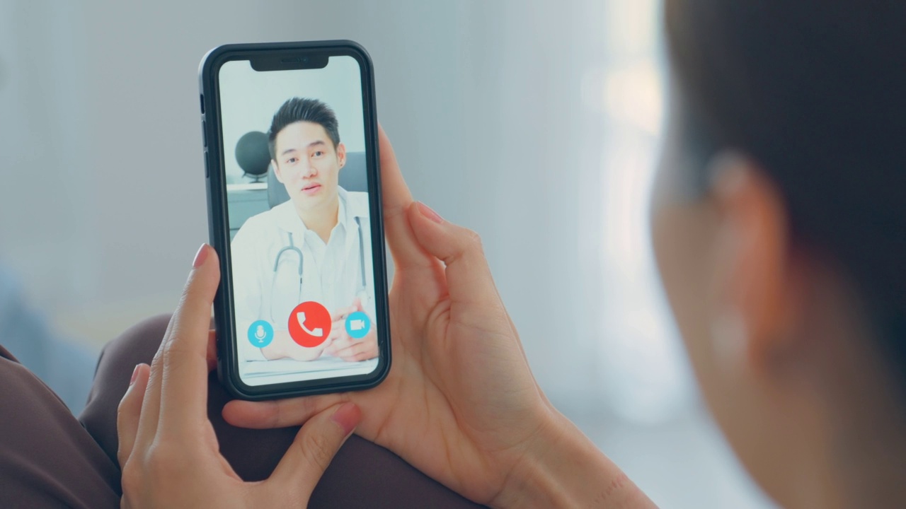 亚洲年轻女性病人在网上与医生聊天。有吸引力的医生给远程健康远程医疗视频电话互联网咨询诊断治疗生病的女孩在家里。视频素材
