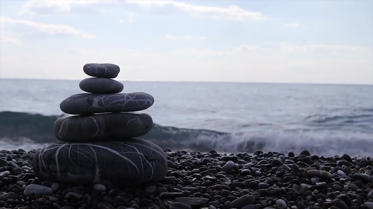 金字塔上的石头，沙滩上的鹅卵石，背景是模糊的大海，黎明的背景。视频素材