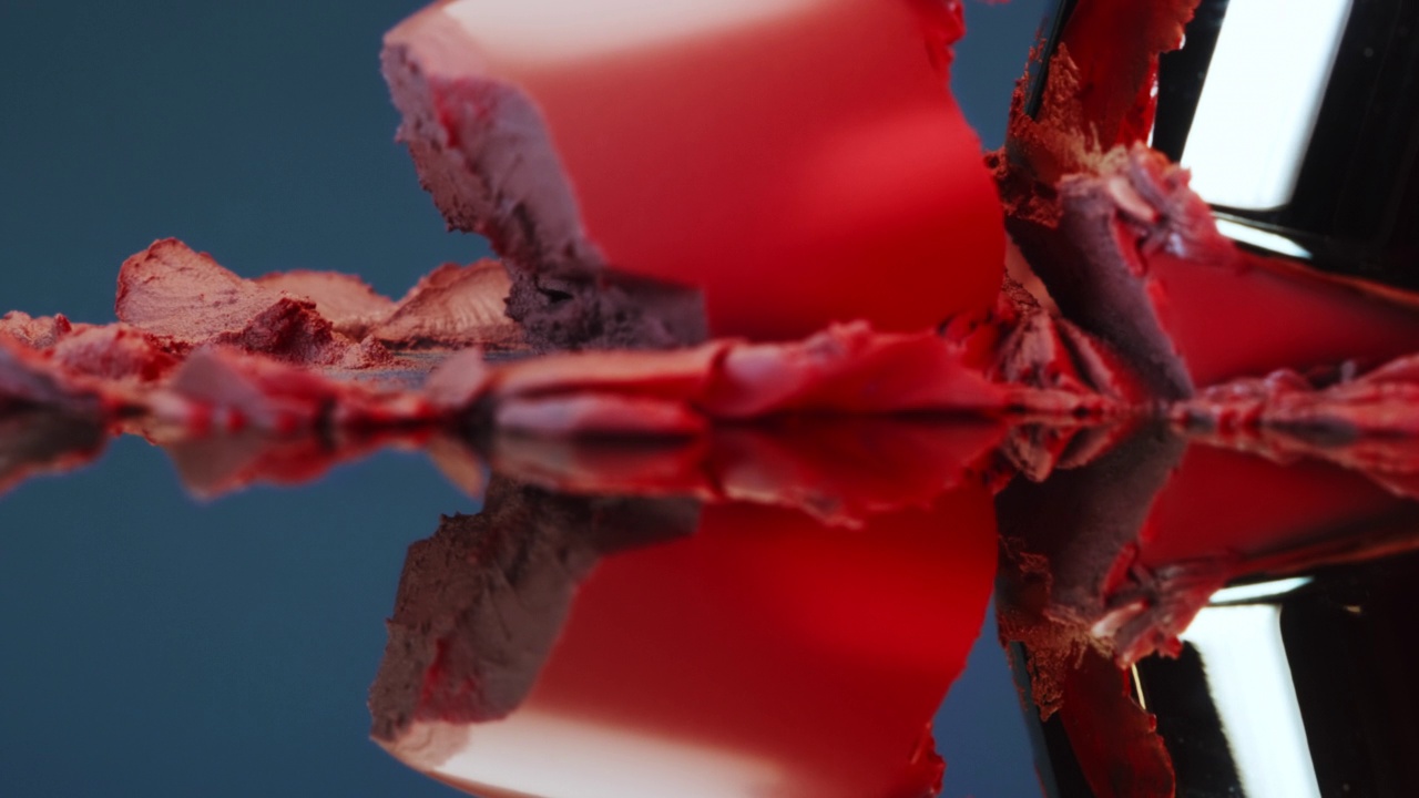 红色保湿唇膏砸在玻璃上的特写视频素材