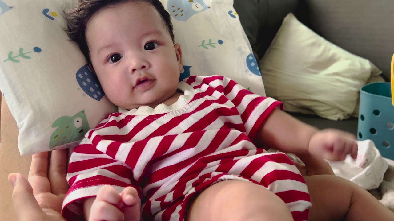 可爱的亚洲小男孩的肖像穿着红白条纹衬衫。视频素材