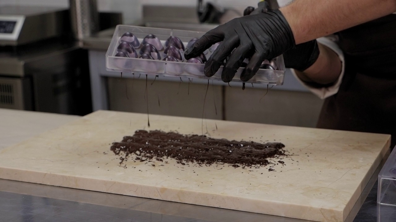 一位男性糕点厨师在专业的糕点厨房手工制作巧克力。视频素材