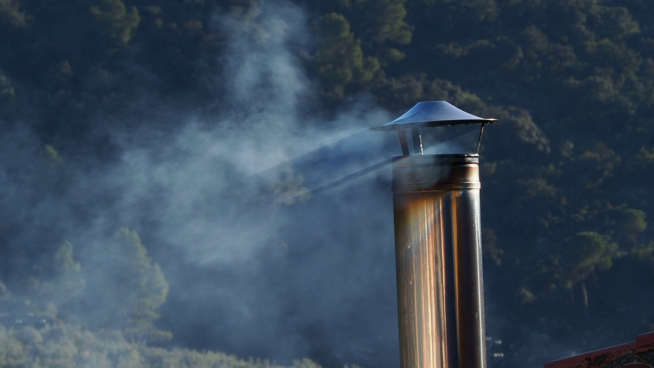 在屋顶上吸烟的冬季烟囱排出污染的烟从柴油供暖。视频素材