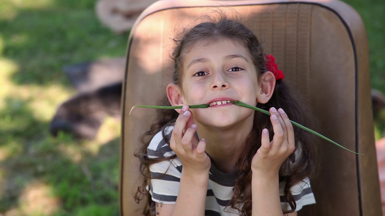 小女孩用葱做假胡子视频素材