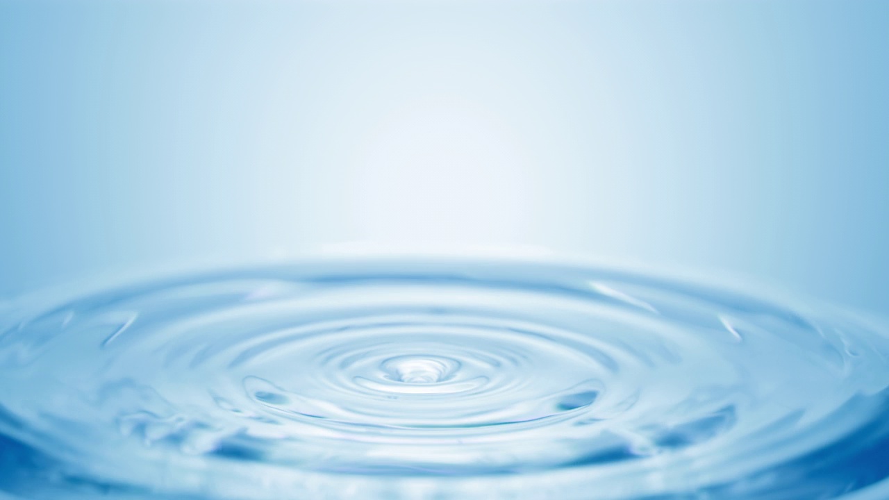 蓝色的水滴落在清澈的液体表面，形成圆圈视频下载