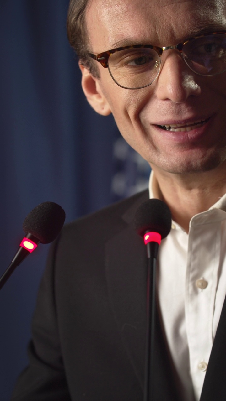 一个年轻的白人政治家在蓝色背景的舞台上演讲的特写镜头视频下载