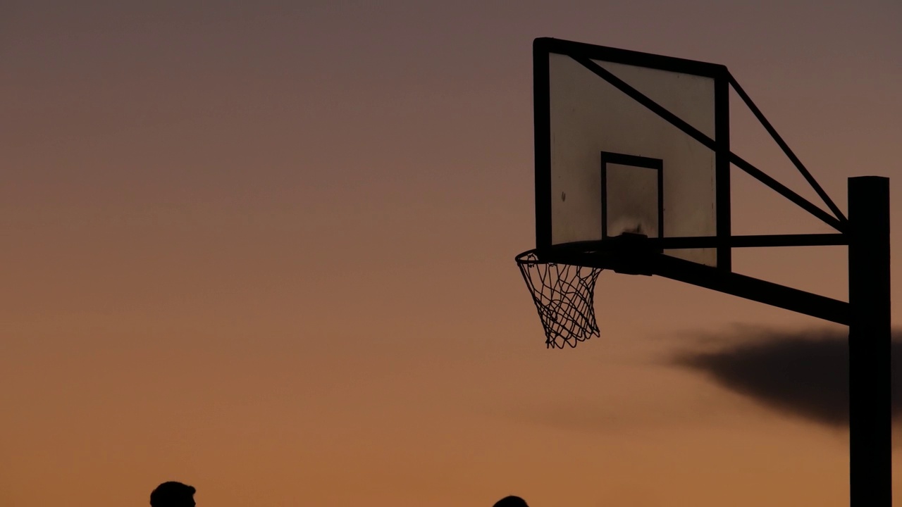 篮圈和篮网为篮球比赛剪影。球员在篮球场打球。视频下载