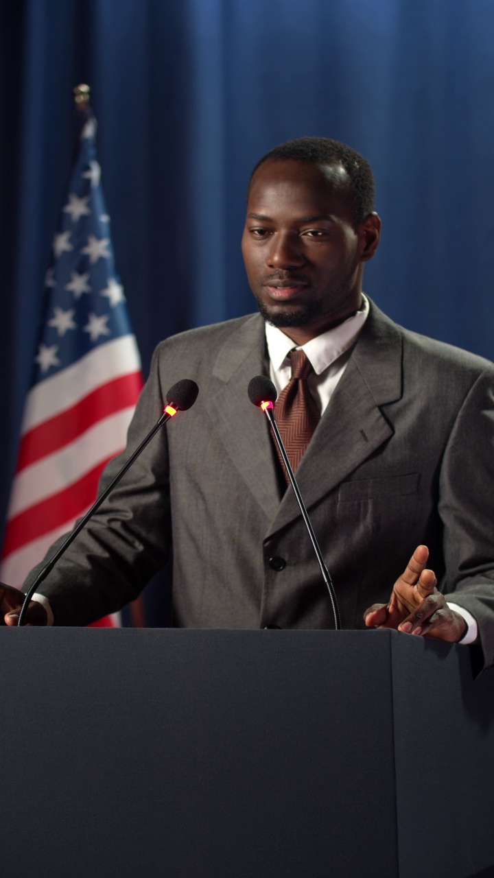 在深蓝色的背景下，年轻的非洲裔美国人在辩论中发表政治演说视频素材