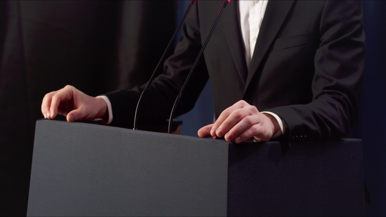 一个年轻的政治家在一次激动人心的演讲中双手紧握成拳头的特写镜头视频下载