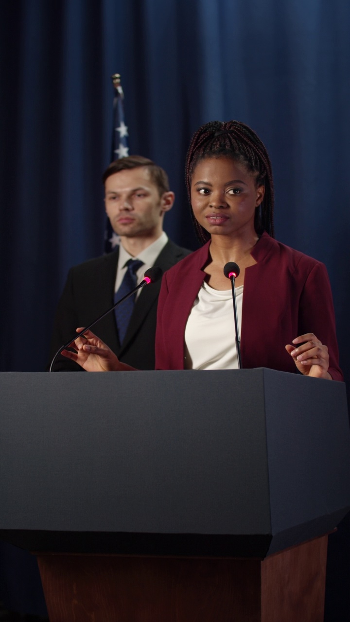 年轻的非洲裔美国政治演讲者在蓝色背景的辩论中视频素材