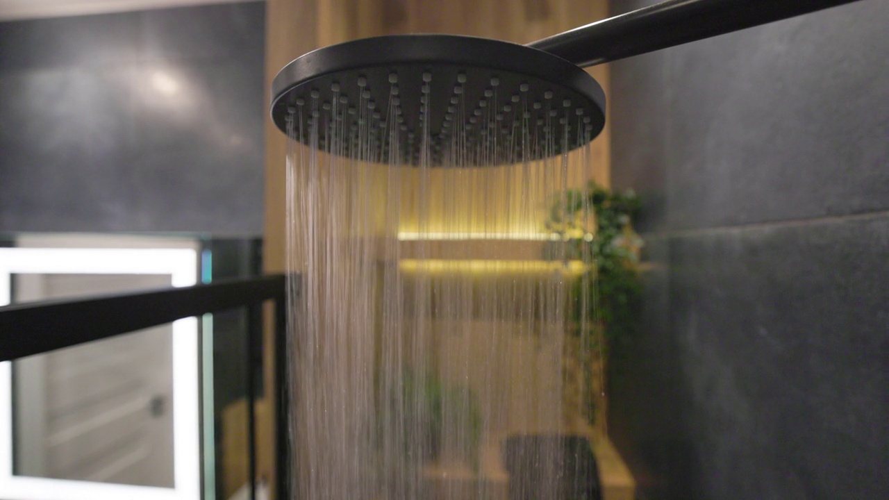 水从雨淋浴头在深蓝色现代豪华浴室。视频下载