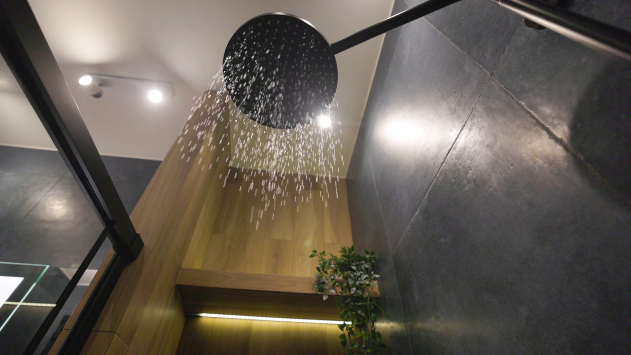 水开始从雨淋浴头在深蓝色现代豪华浴室。视频下载