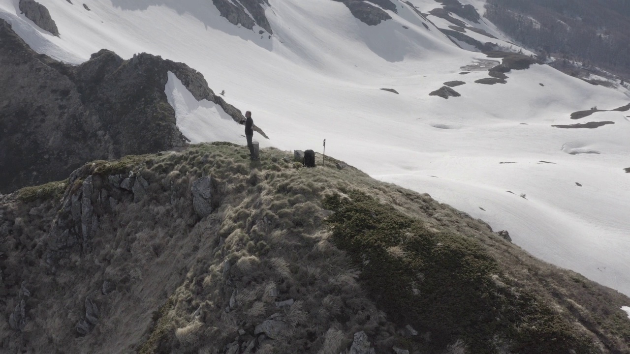 在偏远的雪域的山顶上徒步旅行者视频素材