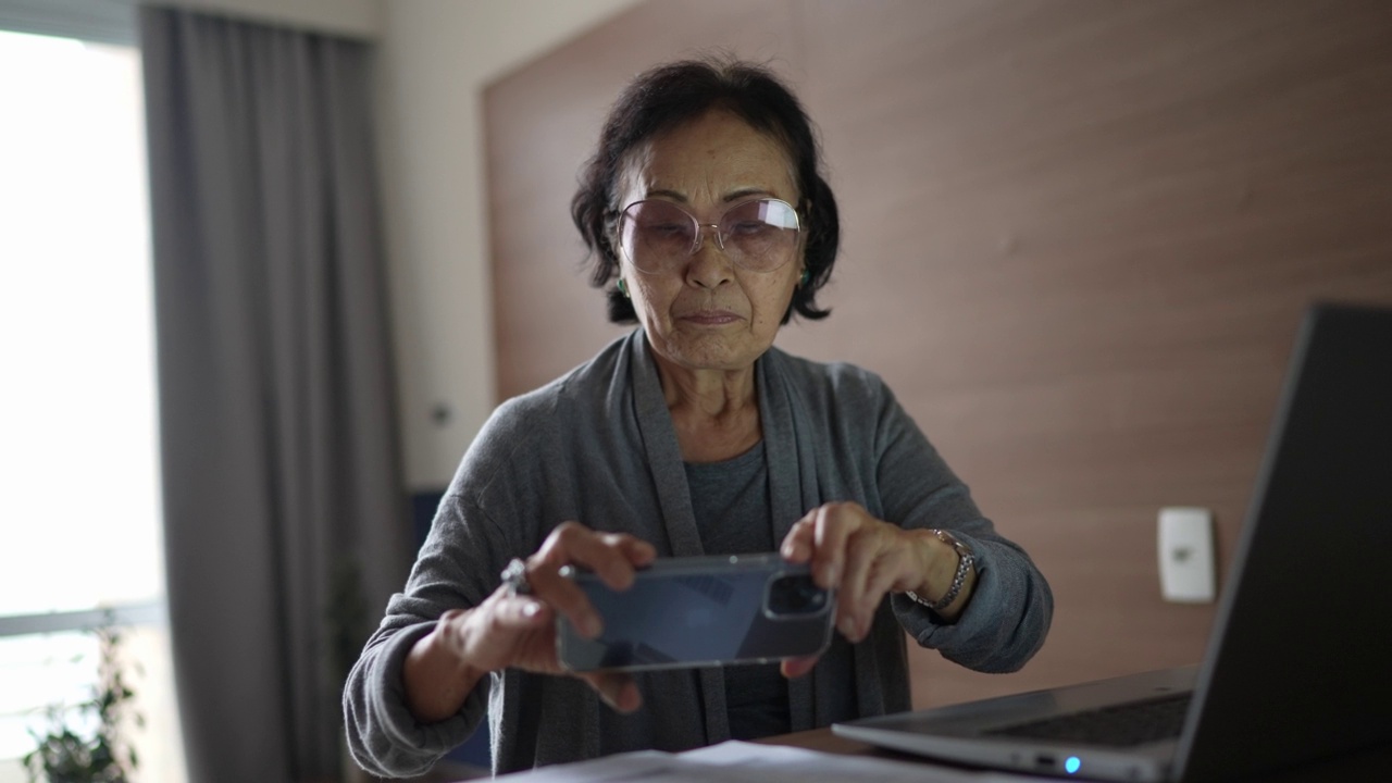 老年妇女在家用手机支付账单视频素材