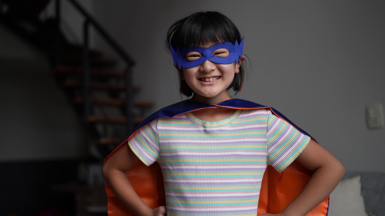 一个打扮成超级英雄的女孩在家里的肖像视频素材