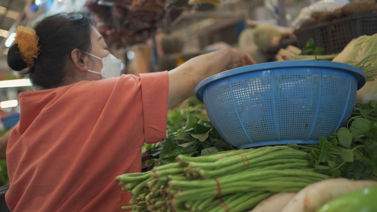 购买蔬菜的亚洲老年妇女。视频素材