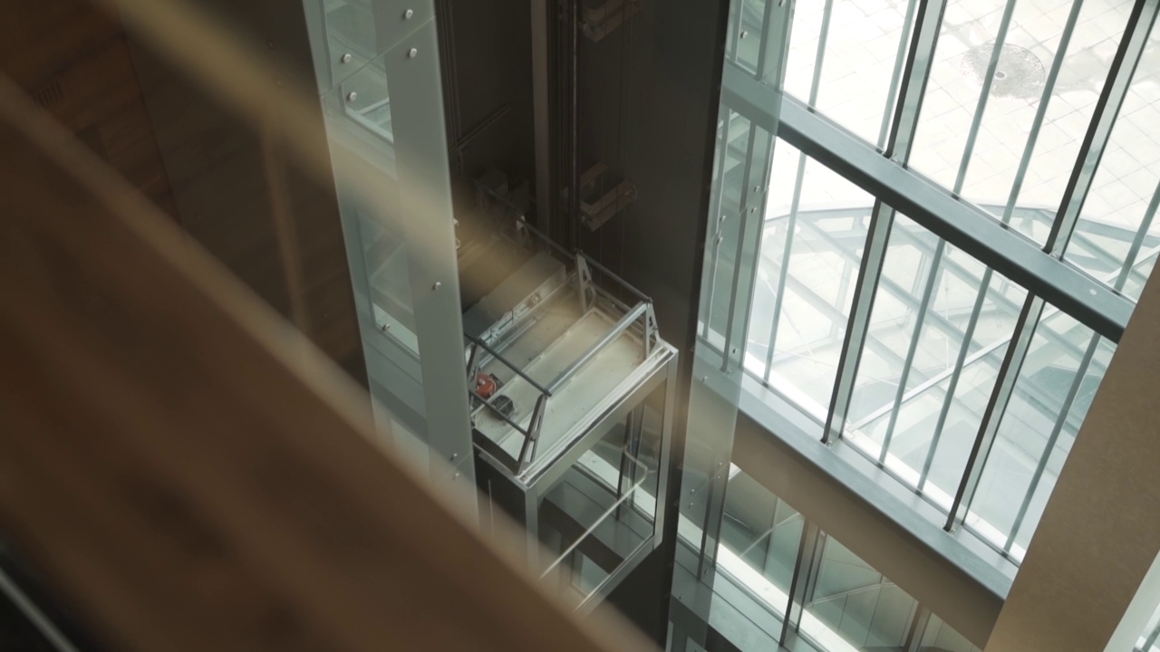 开放式玻璃透明电梯轿厢在建筑内部升起。视频下载