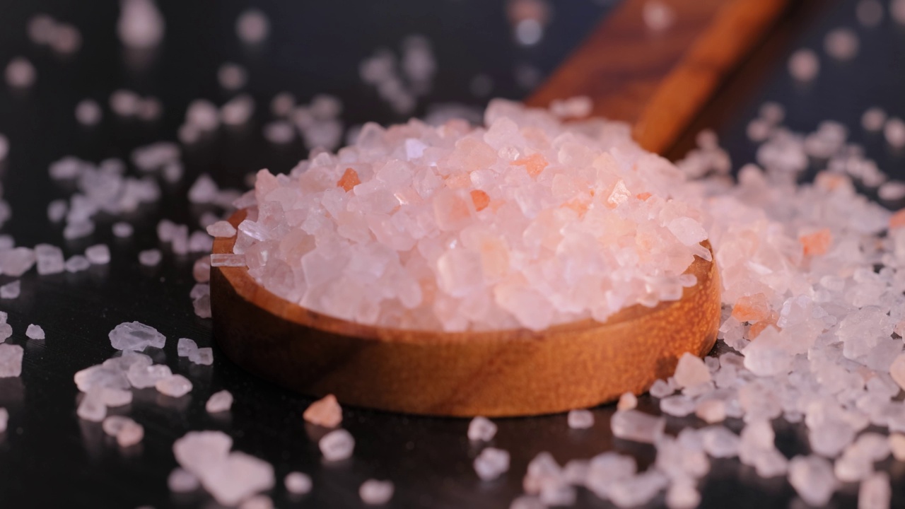 喜玛拉雅粉红色的盐在一个木制被用来调味食物。主要由于营销成本，粉色喜马拉雅盐比普通食盐或海盐贵20倍。视频素材