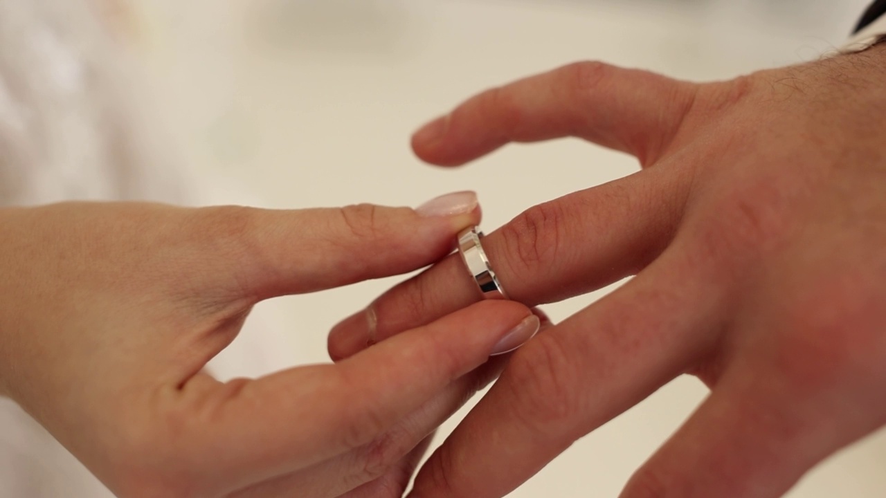 婚礼上，新娘和新郎把结婚戒指戴在手指上视频素材