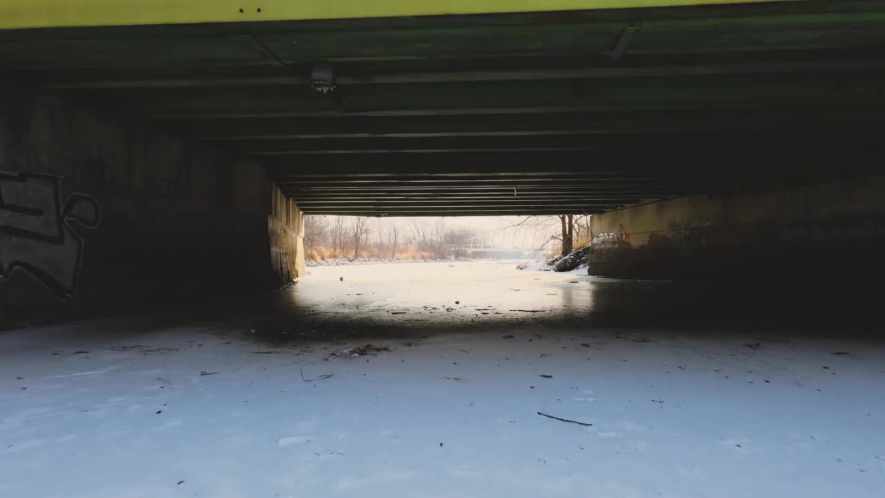 无人机在结冰的河桥下飞行视频下载