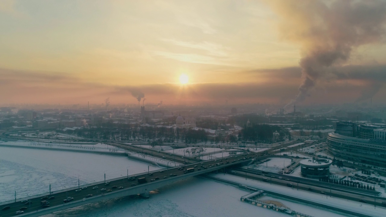 在一个寒冷的冬夜，从有大量冰雪的河的一边，从飞机上看圣彼得堡的日落视频下载