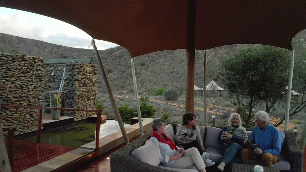 朋友喝葡萄酒狩猎酒店露台在遥远的风景视频下载