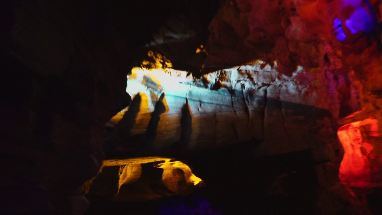 在贵州，乘船穿过一个被灯光照亮的翻新过的天然洞穴视频素材