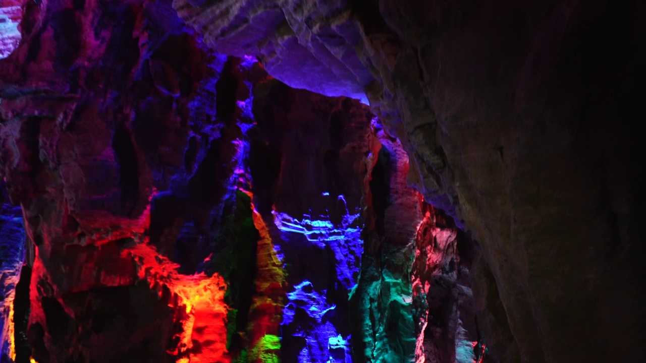 在贵州，乘船穿过一个被灯光照亮的翻新过的天然洞穴视频下载