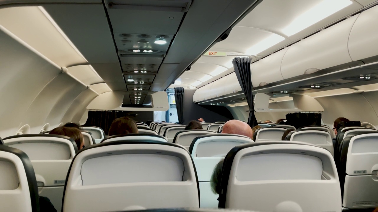 飞机内部的4K特写飞行中显示了无法识别的人享受飞行到一个新的目的地。旅游，旅游，冒险，商业，商业和航空行业营销的概念镜头。视频素材