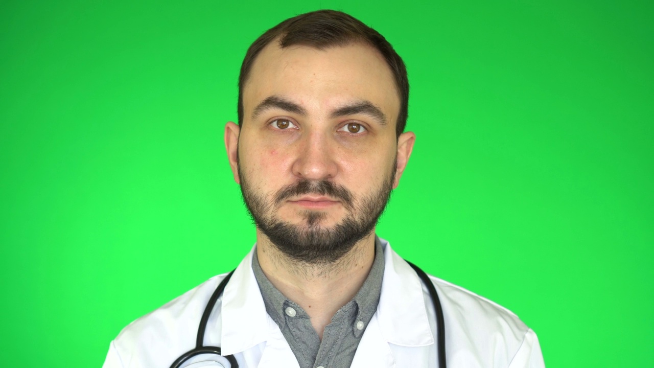 年轻的白人医生的肖像谁看着相机在绿色屏幕背景视频下载