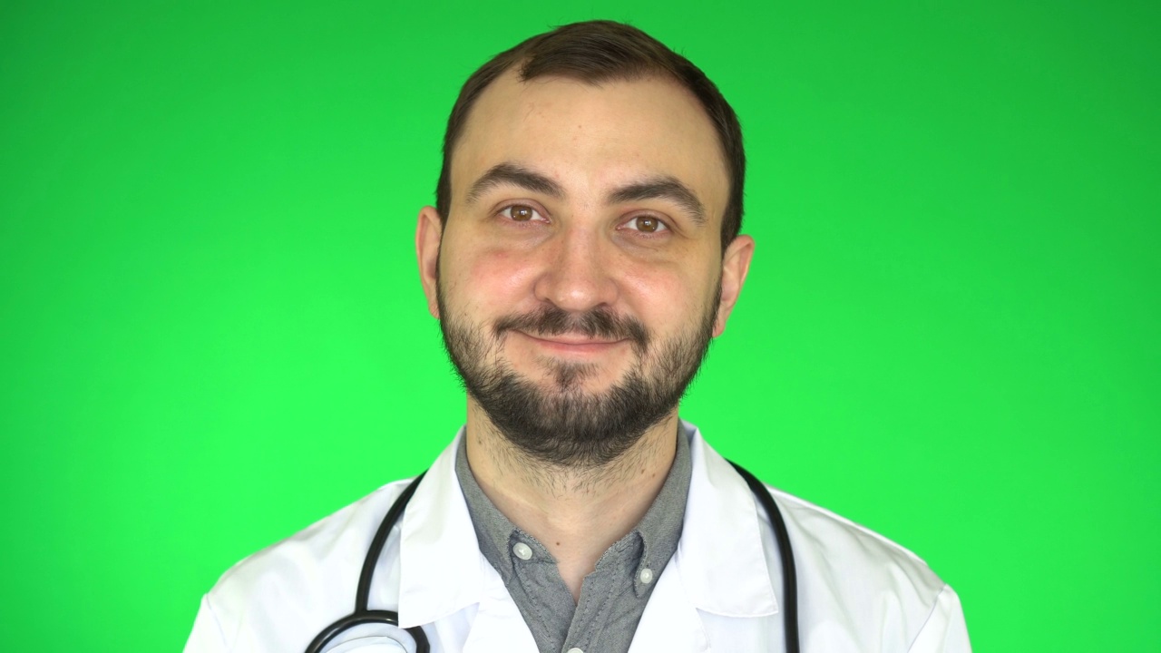 英俊的医生男人看着镜头和微笑的绿色屏幕背景视频下载