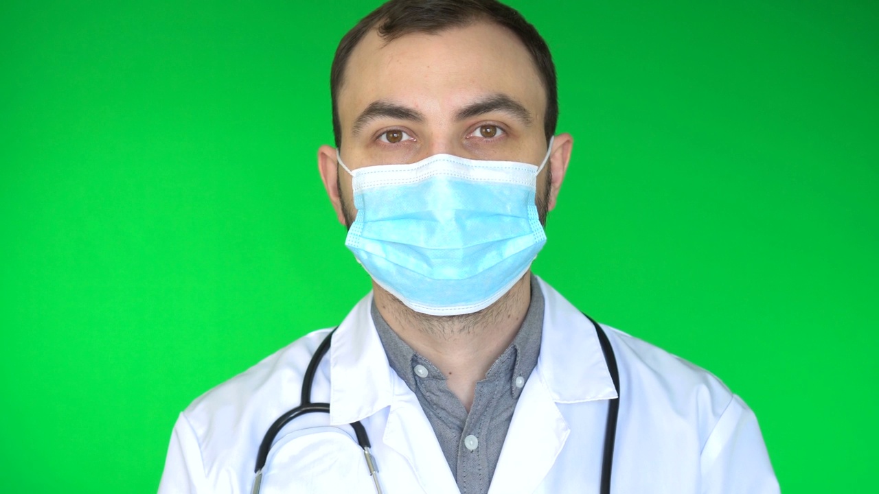 医生戴上防护口罩。绿色屏幕背景，色度键。视频下载