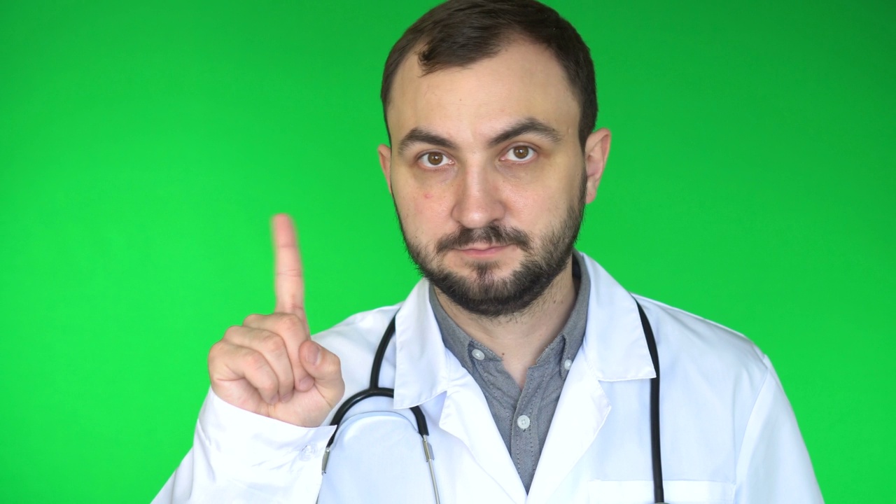 医生看着摄像机，挥动手指拒绝。绿屏背景视频下载