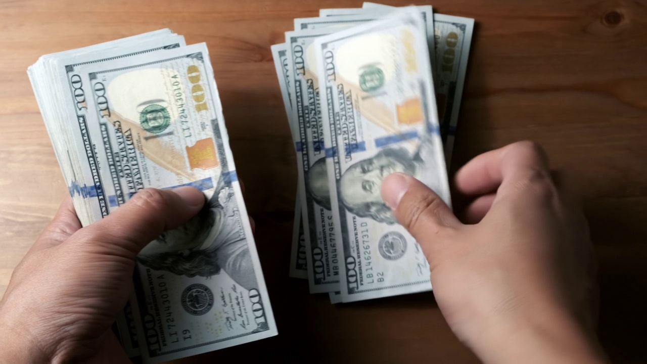 男人用手数着美元钞票。收入和业务概念。视频下载